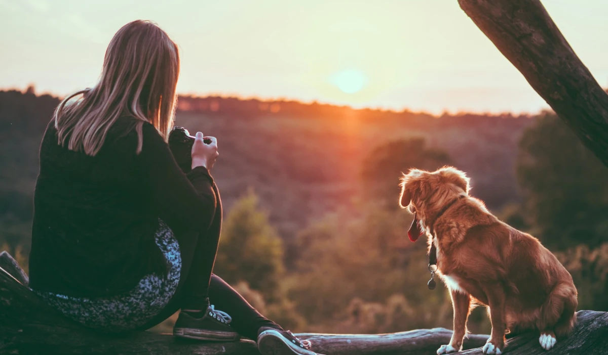 Ideal client sitting peacefully with their pet in a natural setting