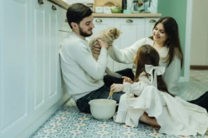 Peaceful family scene with child, parents, and calm cat sitting together in living room, showing harmonious adjustment to family changes